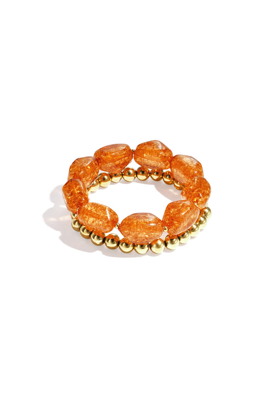 Set van twee kralenarmbanden met oranje kralen en goudkleurige details