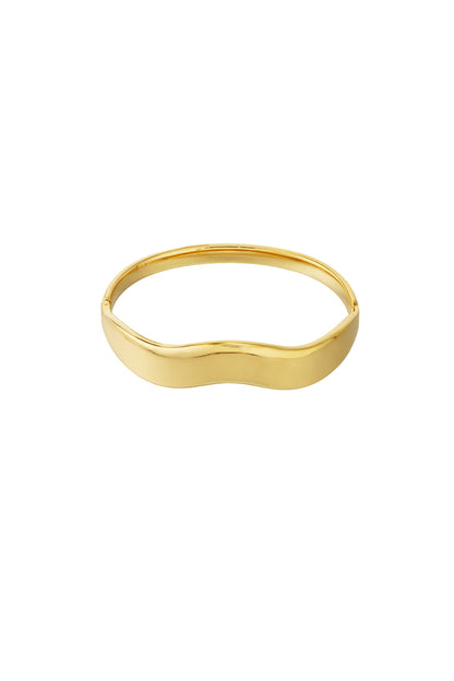 Gouden wave bangle armband van roestvrij staal gedragen om de pols