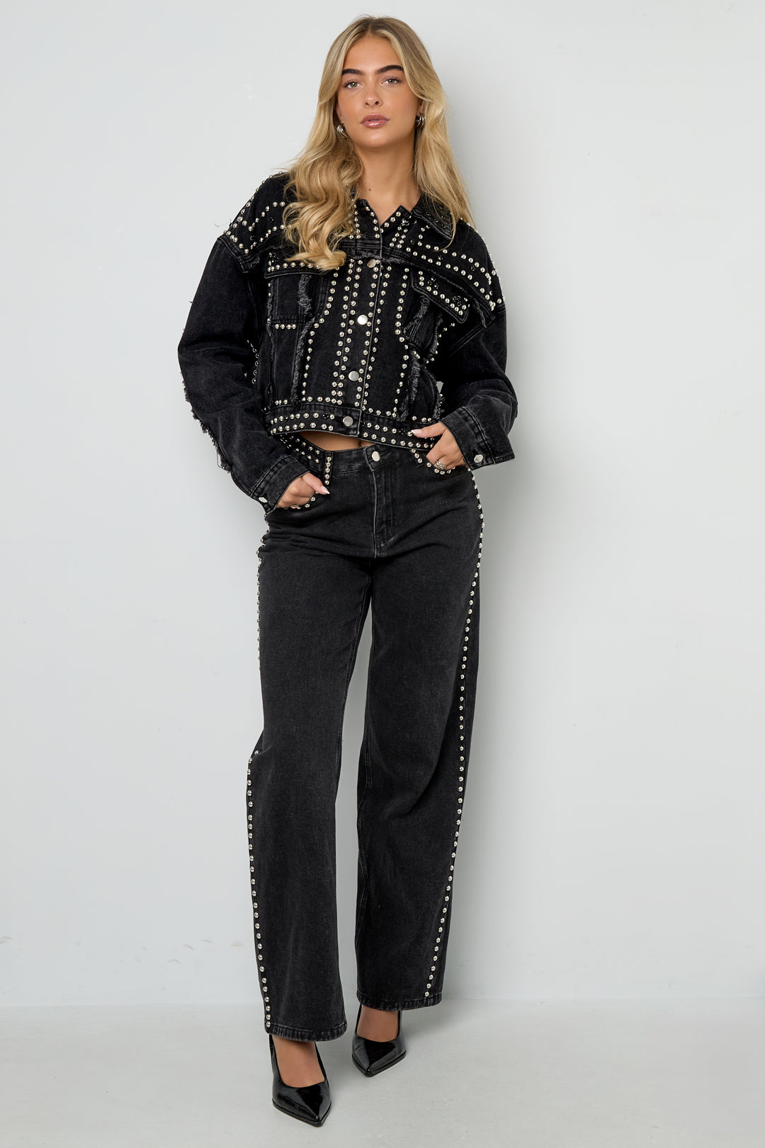 Model draagt zwarte jeans met studs
